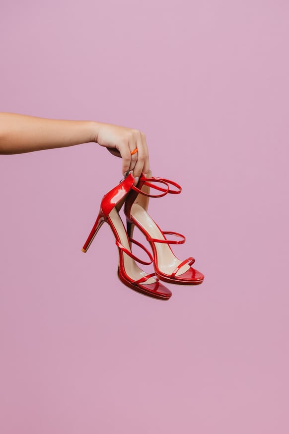 Person Holding a Pair of Red Heels 